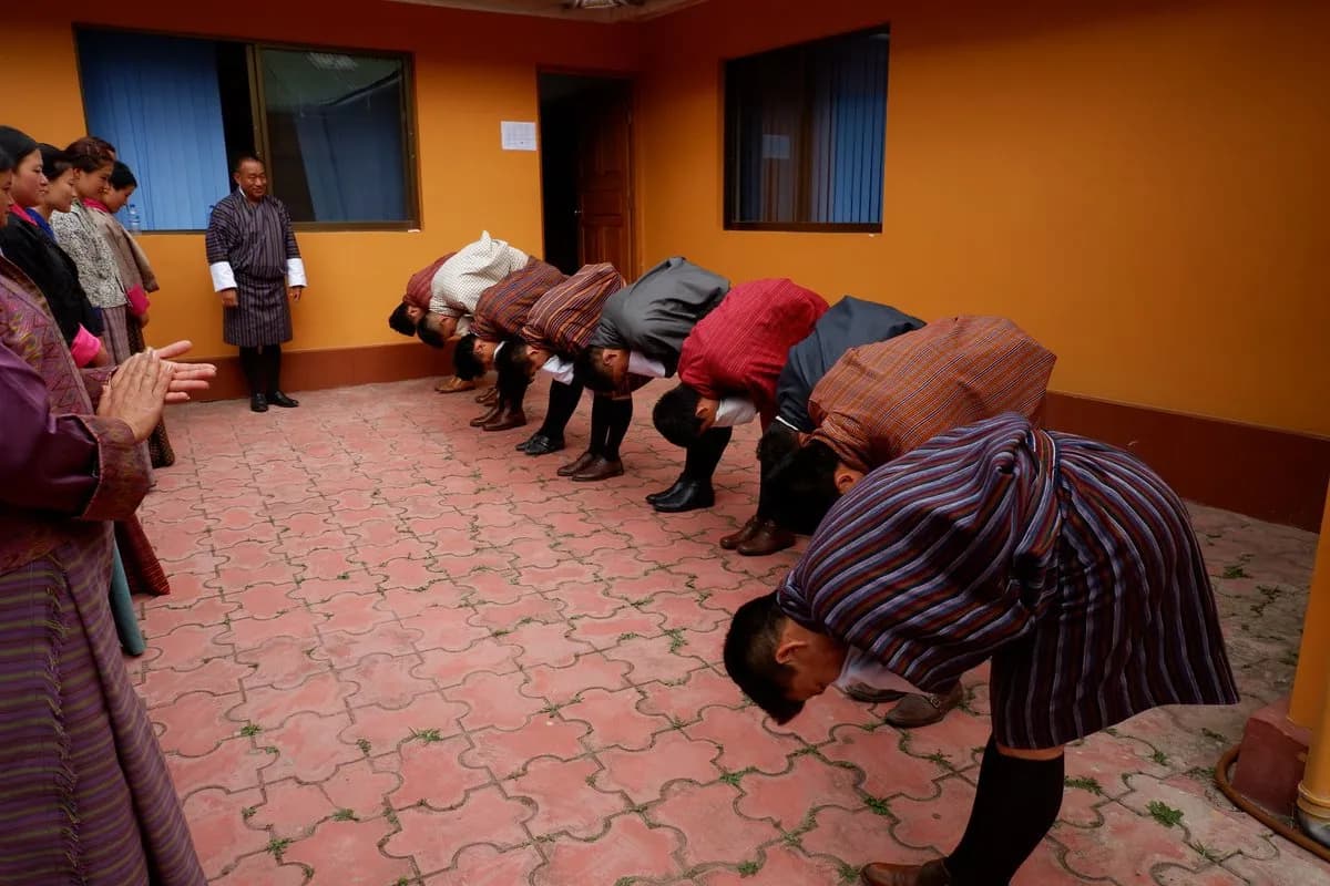 Bhutanese men and women in gho and kira, at practice of driglam namzha — the country’s code of conduct